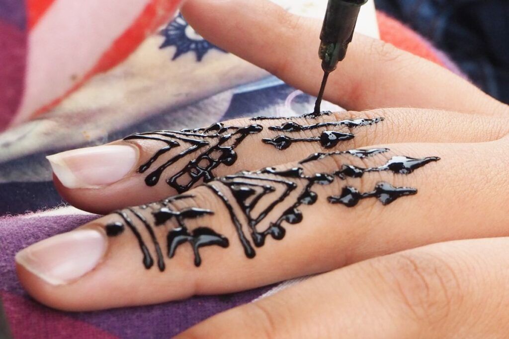 Henna tattoos being put on girls hand in Morocco